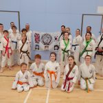 Tang Soo Do students and instructors in front of association flag showing new belts