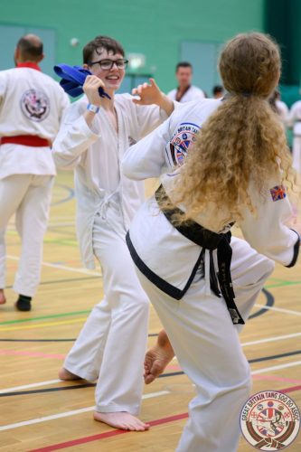 Two students sparring in a training hall at the club's August 2026 clinic
