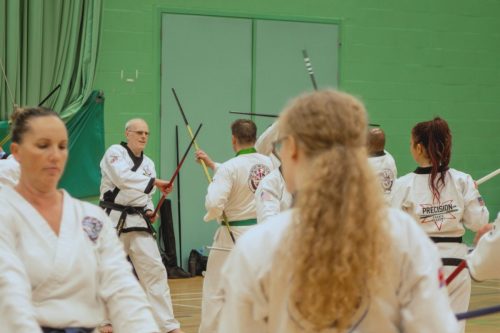 Students practising bo staff techniques at the August 2026 GBTSDA clinic