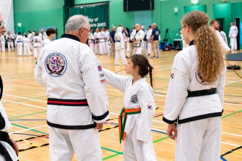 A senior instructor walking with a young student at the August 2026 GBTSDA clinic